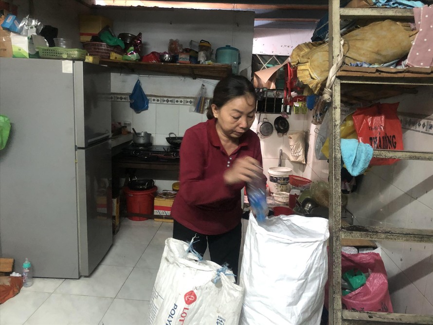 Bà Huỳnh Thị Thu Thạnh tranh thủ nhặt ve chai đem về phòng trọ sau giờ tan ca 