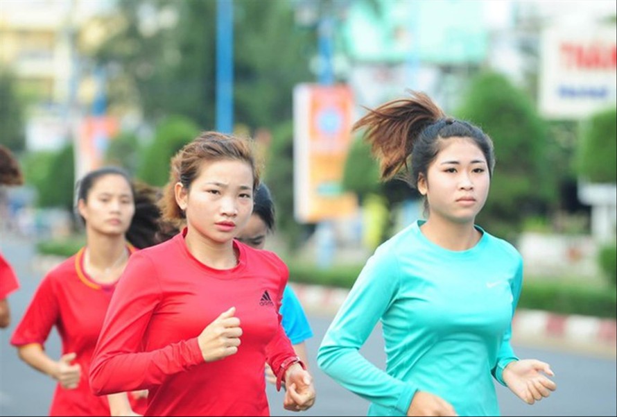 Vận động viên Nguyễn Thị Oanh (hàng trước, bên trái) rèn luyện để tranh tài trên đường chạy báo Tiền Phong