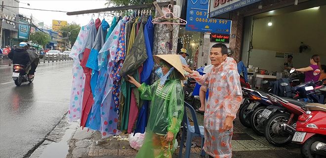 Hiệp sĩ Trần Văn Hoàng phụ vợ bán hàng rong trên phố Ảnh: Văn Minh 