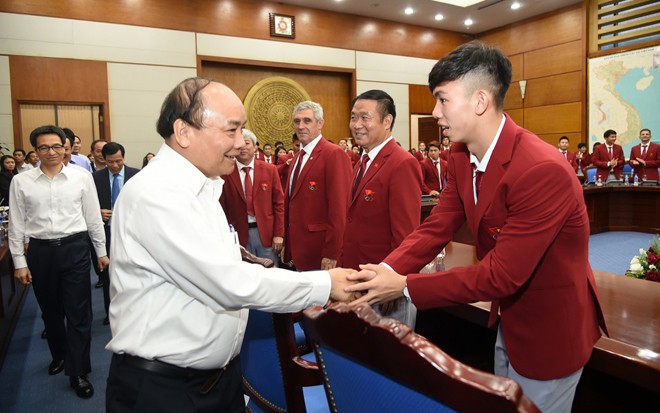 Thủ tướng Nguyễn Xuân Phúc chúc mừng Huy Hoàng trong buổi gặp mặt chúc mừng Đoàn Thể thao Việt Nam thi đấu thành công tại Asian Games 2018. ảnh: TTX 