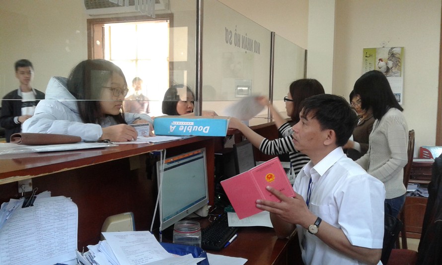 Cán bộ bộ phận một cửa của UBND phường Phú Thượng (quận Tây Hồ) hướng dẫn người dân làm thủ tục hành chính. Ảnh: Nhật Minh