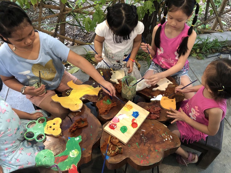 Các bé say sưa vẽ màu trên gỗ tại workshop “Xưởng mộc của bé” Ảnh: PV 