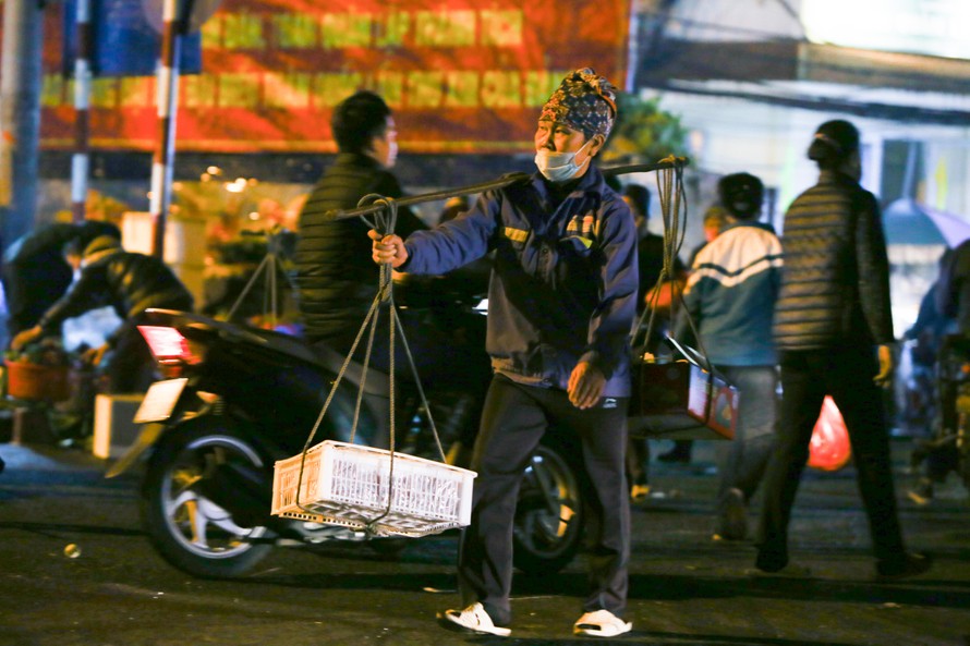 Chị Phạm Thị Lụa gánh hàng thuê tại chợ Long Biên lúc 4 giờ sáng Ảnh: Đức Văn