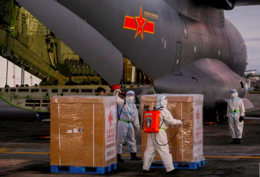 Các nhân viên y tế Philippines dỡ lô vắc-xin do máy bay quân sự Trung Quốc đưa đến ảnh: Reuters 