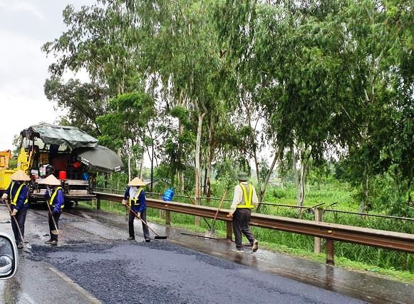 Rải thảm nhựa mặt đường cao tốc Hà Nội - Thái Nguyên giữa trời mưa.
