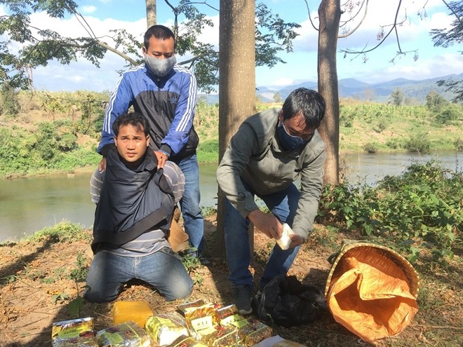 Đối tượng người Lào Xang Thong Buoi La Van (quỳ gối) bị bắt giữ cùng tang vật 10 kg ma túy đá và 20 ngàn viên MTTH.