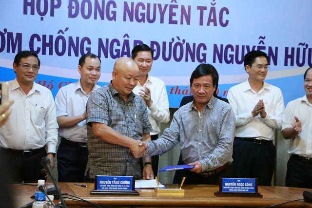 Ông Nguyễn Ngọc Công (bên phải) ký hợp đồng thuê siêu máy bơm đường Nguyễn Hữu Cảnh.