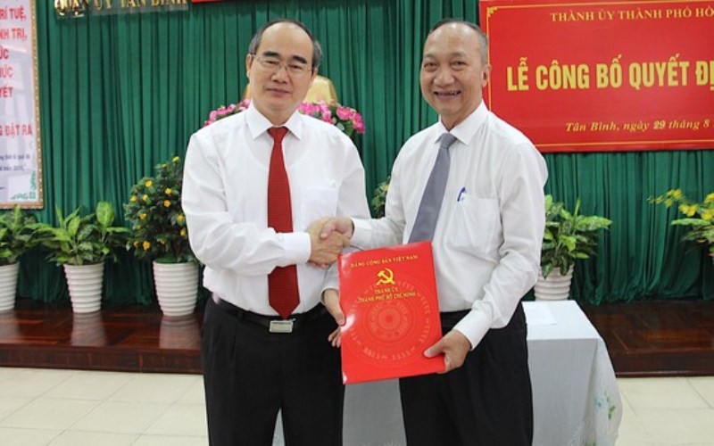Ông Kiều Bình Chung (phải) Bí thư Quận ủy quận Tân Bình nhận quyết định nghỉ hưu từ ngày 1/9