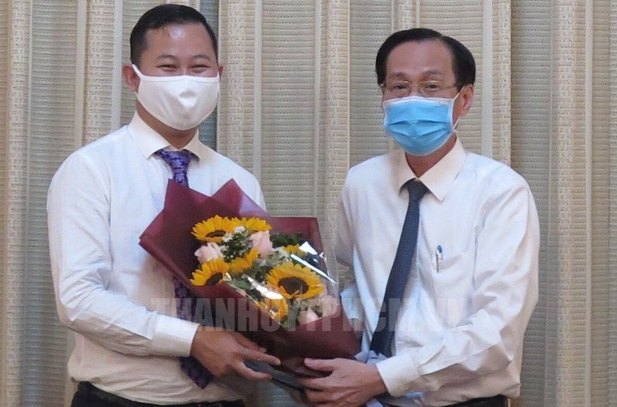 Ông Trần Phú Lữ (trái) nhận quyết định điều động từ Phó Chủ tịch UBND TPHCM Lê Thanh Liêm. Ảnh: Thành ủy TPHCM
