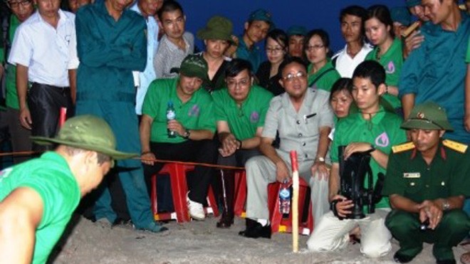 Nguyễn Thanh Thúy (mặc áo xám - ngồi) đang trực tiếp chỉ đạo việc tìm kiếm cất bốc hài cốt rởm tại xã Gio Mai, huyện Gio Linh, tỉnh Quảng Trị vào năm 2013. 