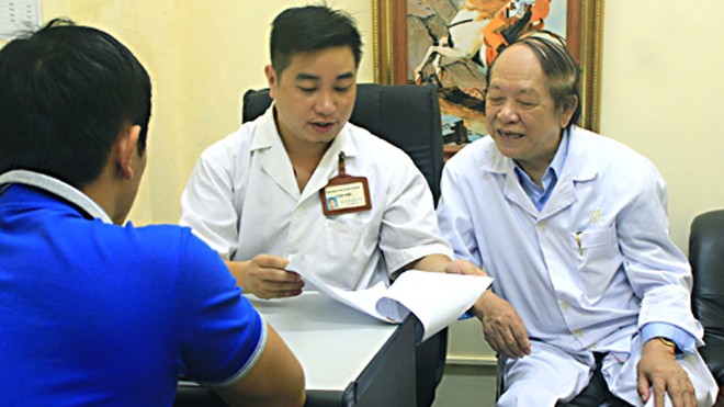 Giáo sư Trần Quán Anh (phải) cùng đồng nghiệp tư vấn cho bệnh nhân nam khám vô sinh. Ảnh: MT.