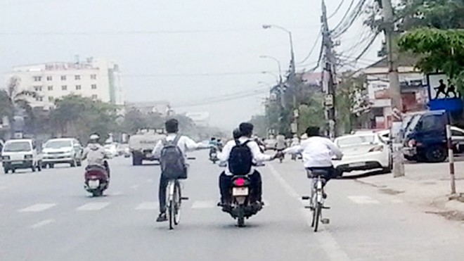 "Tổ hợp xe kéo" của 4 học sinh đang "làm xiếc" trên đường Quốc lộ 1A đoạn đi qua phường Quán Bàu (Tp Vinh, Nghệ An). 
