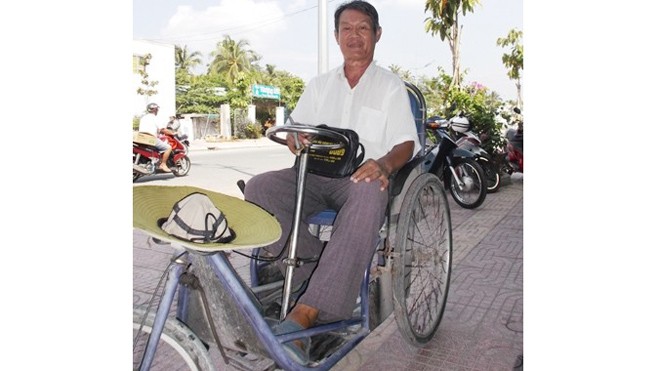 Ông Nguyễn Xuân Trương chật vật bên chiếc xe lắc của mình đi bán vé số để làm từ thiện. 