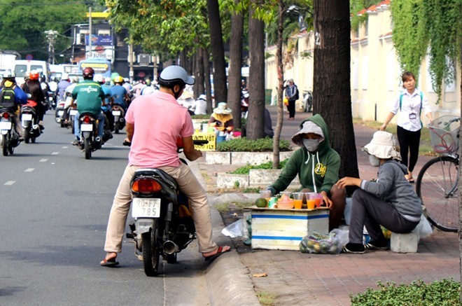 Khách ghé mua cam vắt trên đường Nguyễn Hữu Cảnh. 