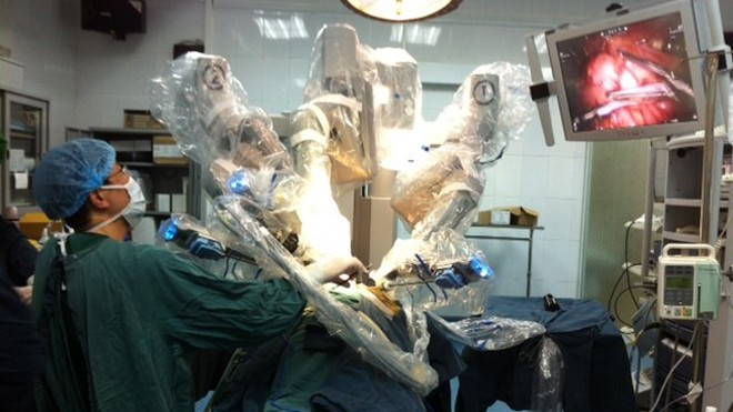 Những cánh tay robot đang tiến hành phẫu thuật nội soi cho em bé. (Ảnh: Thùy Giang/Vietnam+)