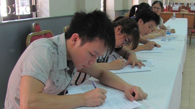 Thí sinh viết giấy cam đoan tại Học viện Công nghệ Bưu chính Viễn thông. Ảnh: Phạm Mai/Vietnam+