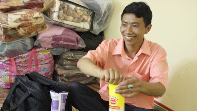 Chàng trai dân tộc Mông vui mừng vì được tình nguyện viên tặng bánh mì trong căn phòng trọ dự thi đại học.