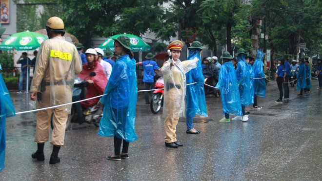Nữ cảnh sát giao thông đội mưa làm nhiệm vụ tại điểm thi