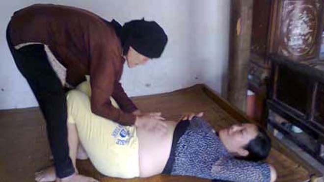 Bà Tích đang chữa sa hố cho thai phụ bằng cách vuốt bụng.