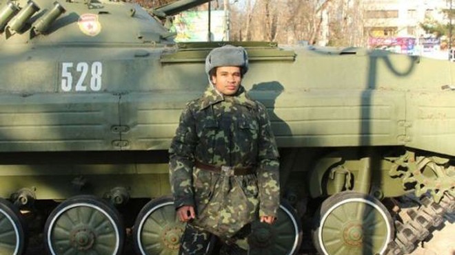 Beness Aijo đứng cạnh một chiếc xe tăng ở Ukraina. Ảnh: Mirror 