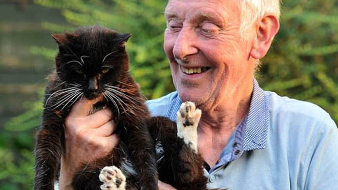 Mèo Olive 24 tuổi và người chủ nuôi John Burgess. Ảnh: Manchester Evening News.