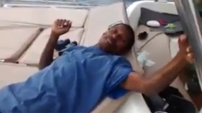 Raymundo nằm bệt xuống thuyền sau khi được cứu lên từ biển. Ảnh chụp từ video.