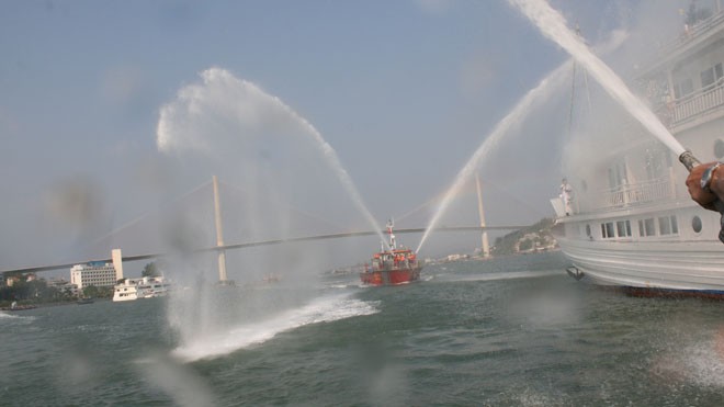 Tàu của lực lượng chữa cháy Quảng Ninh phun vòi rồng dập lửa.