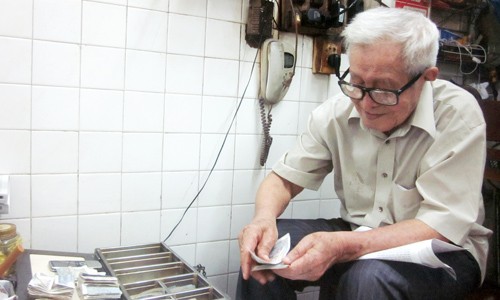 90 tuổi, ông Phồn vẫn minh mẫn ngồi thu và trả tiền dư cho khách mỗi ngày. Ảnh: Thi Hà/ VnExpress