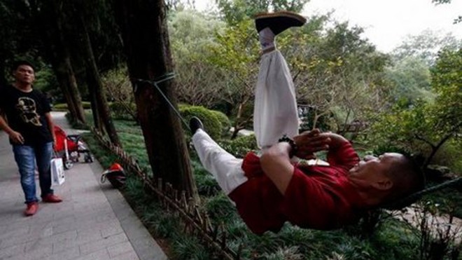 Ông Liang có thể nằm thăng bằng và tập luyện ngay trên sợi dây thừng. 