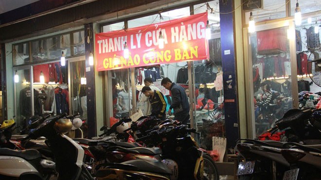 Nhiều cửa hàng thời trang tại Hà Nội treo bảng giảm giá đồ đông, thậm chí có nơi còn treo biển thanh lý cửa hàng để câu khách ngay những ngày chớm đông. Ảnh: Ngọc Lan. 