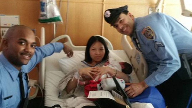 Hai cảnh sát Caban và James chụp ảnh với sản phụ sau khi giúp cô sinh con trên tàu điện ngầm. Ảnh: USA Today