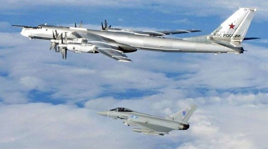 Một chiếc Tu-95 Bear (phía trên) được chiến đấu cơ Typhoon hộ tống ra khỏi không phận Anh tháng 4-2014. Ảnh: UK Mod