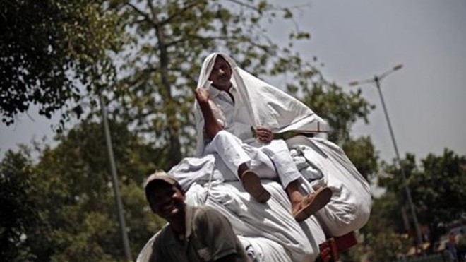 Nắng nóng kéo dài khiến người dân Ấn Độ phải “trùm kín” mới có thể ra ngoài. Ảnh minh họa: Reuters