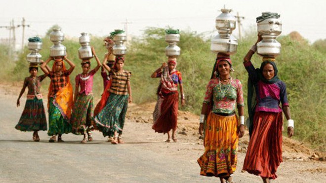 Phụ nữ Ấn Độ đội bình chứa nước lên đầu. Ảnh: OddityCentral