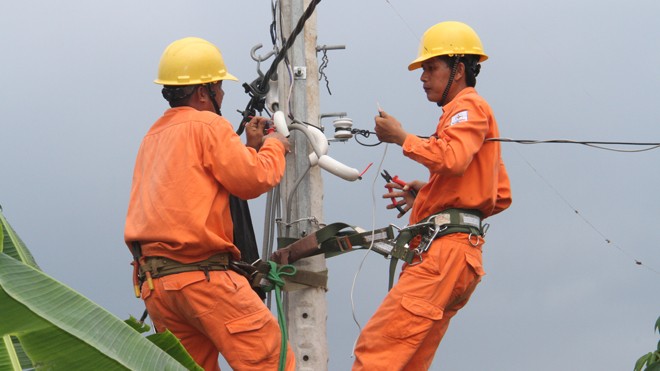 Nhân viên Công ty Điện lực Vĩnh Long lắp đặt nhánh rẽ đưa điện vào nhà hộ dân tại ấp Trung Điền, xã Trung Hiếu, huyện Vũng Liêm (Vĩnh Long).
