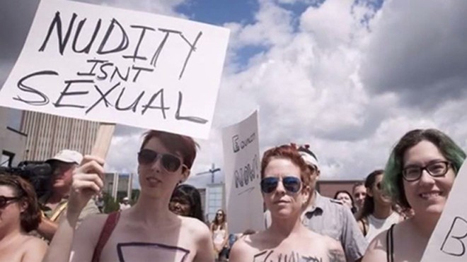 Nhiều phụ nữ để ngực trần tham gia cuộc biểu tình. Họ cầm biểu ngữ viết "Khỏa thân không phải là nhục dục". Ảnh: RT