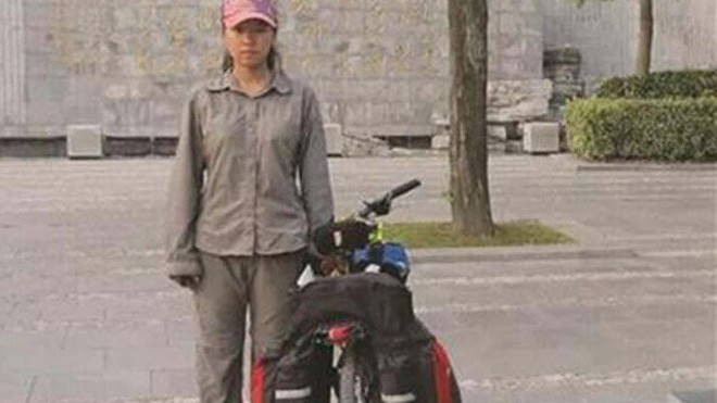 Nữ sinh Yang Wanying đứng bên cạnh chiếc xe đạp đã cùng em vượt 2.500 km để tới trường đại học nhập học.