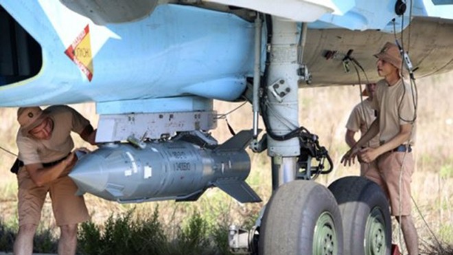 Các binh sĩ Nga tại căn cứ không quân Hmeimim, Syria, lắp một quả bom thông minh dẫn đường qua vệ tinh cho chiến đấu cơ Su-34. Ảnh: AP