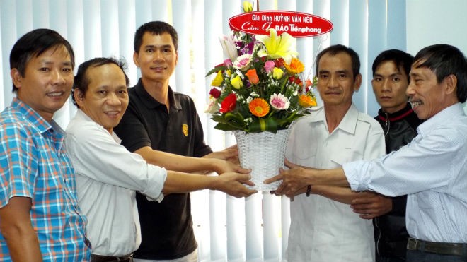 Ông Huỳnh Văn Nén (áo trắng ôm lẵng hoa) cùng con trai Huỳnh Thành Lượng và ông Nguyễn Thận (ngoài cùng bên phải) đến Cơ quan đại diện báo Tiền Phong tại Thành phố Hồ Chí Minh để cảm ơn, ngày 4/11/2015