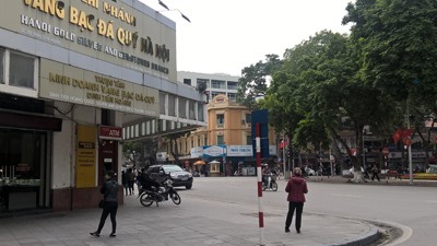 Hai đối tượng "cò" đổi tiền đô la và tiền lẻ tại phố Nguyễn Xí, giao cắt phố Đinh Tiên Hoàng (Hoàn Kiếm, Hà Nội)