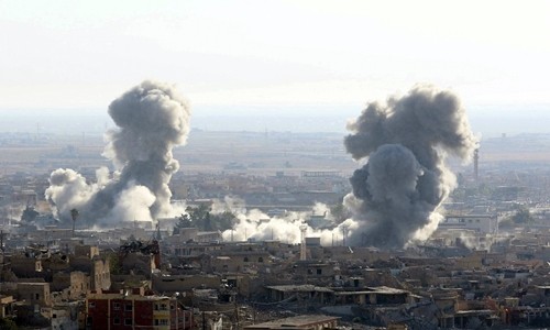 Khói bốc lên sau một đợt không kích của liên minh quốc tế ở thị trấn Sinjar, Iraq. Ảnh: Reuters.