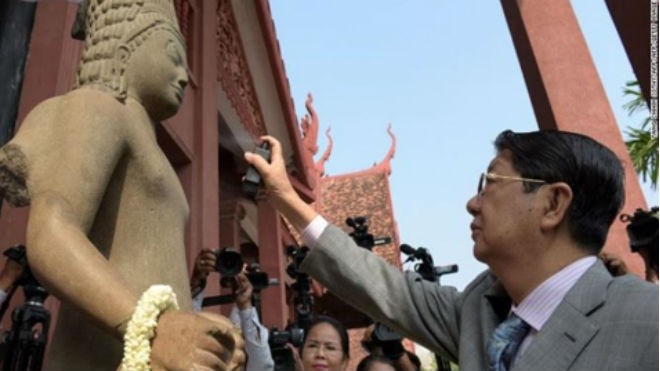 Phó Thủ tướng Campuchia Sok An xịt nước hoa lên pho tượng thần Harihara trong buổi lễ nối đầu và thân tượng ở Bảo tàng Quốc gia tại Phnom Penh. Ảnh: CNN