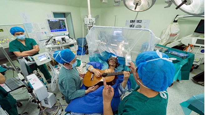 Nhạc sĩ Li chơi đàn trong ca phẫu thuật não để chữa trị chứng loạn trương lực cơ. Ảnh: Rex