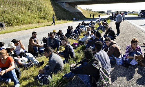 Người di cư ngồi nghỉ bên đường ở phía nam Đan Mạch hồi tháng 9 năm ngoái. Ảnh: AP