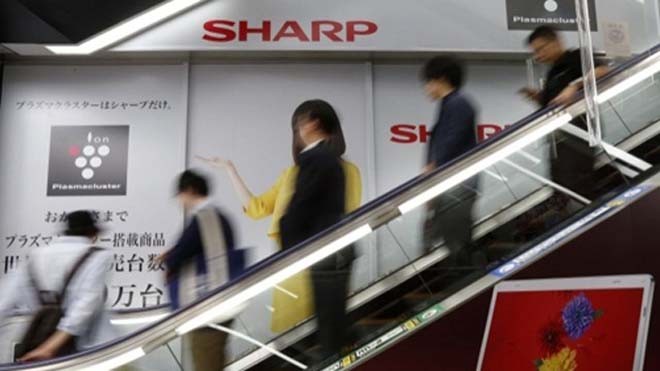 Khách hàng đi qua một quảng cáo của Sharp trong siêu thị. Ảnh: Bloomberg