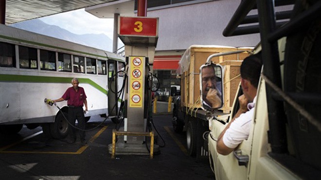 Người dân đổ xăng tại một trạm xăng ở Caracas (Venezuela). Ảnh: Bloomberg