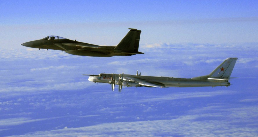 Tu-95 (phải) được một chiến đấu cơ F-15C Eagle của Mỹ tháp tùng khi bay gần Alaska. (Ảnh: AP)