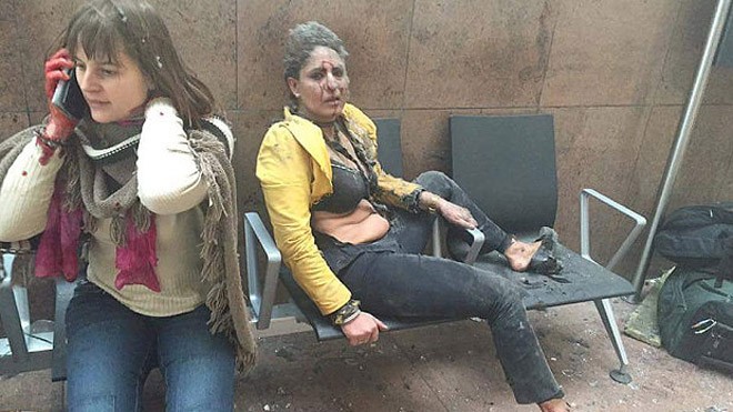 Nidhi Chaphekar (áo vàng) mặt đầy vết máu sau vụ đánh bom tại sân bay Zaventem (Ảnh: AP)