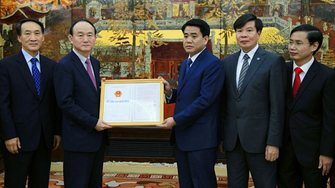 Ông Nguyễn Đức Chung trao giấy chứng nhận đăng ký đầu tư cho Samsung.