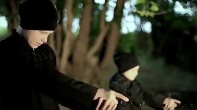 Hai bé trai người Pháp giơ súng ngắm bắn các tù nhân Syria trong đoạn video do Nhà nước Hồi giáo công bố. Ảnh: Mirror 